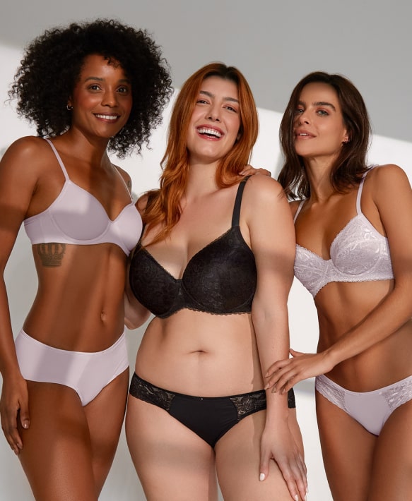 Diverse lingerie collection showcased by three confident women in a warm, stylish setting.