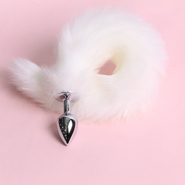 Sleek chrome metal plug with fluffy white faux fur tail on pink backdrop.