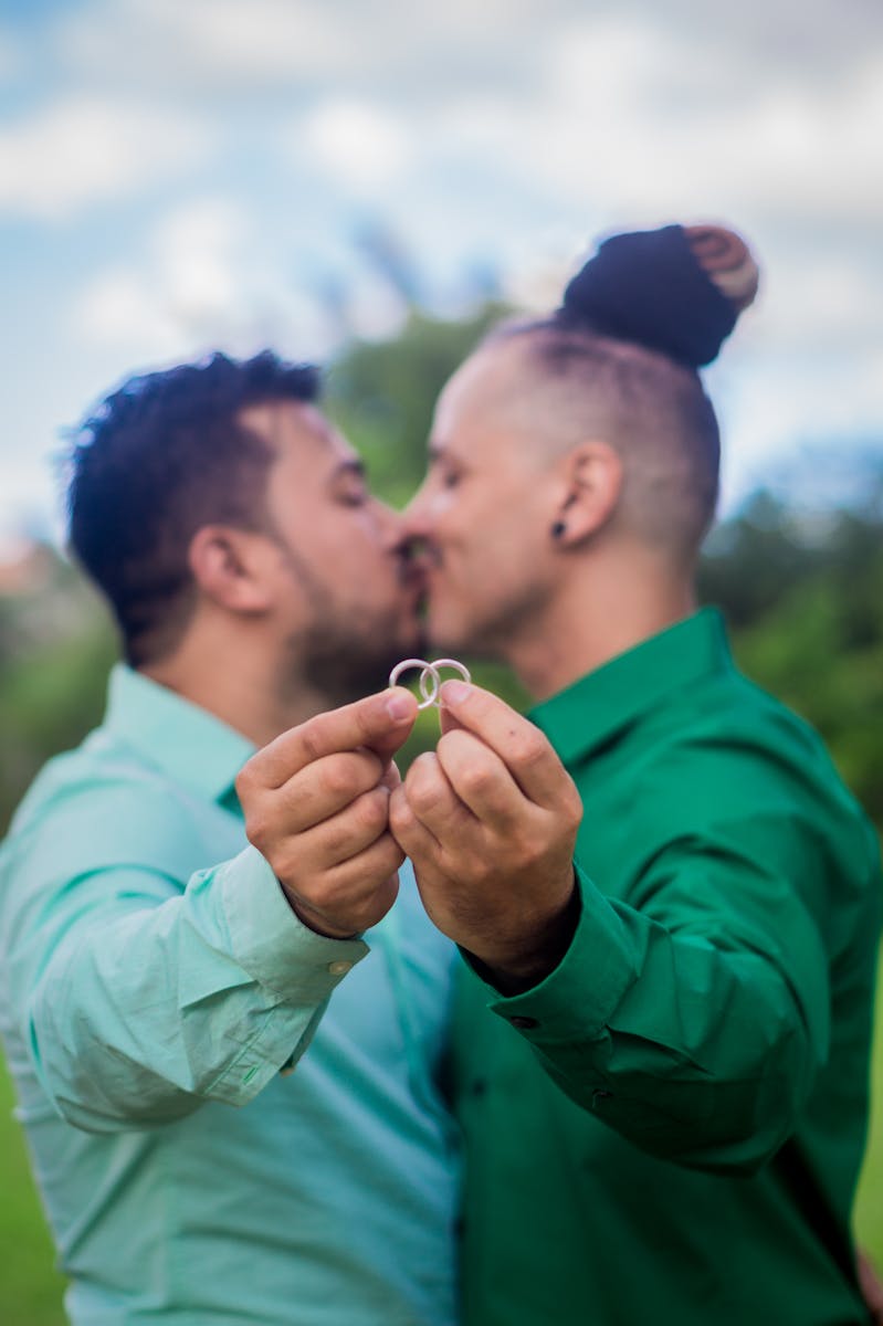 Un couple d'amoureux tenant leurs bagues de fiançailles en plein air, témoignant ainsi de leur affection et de leur engagement.