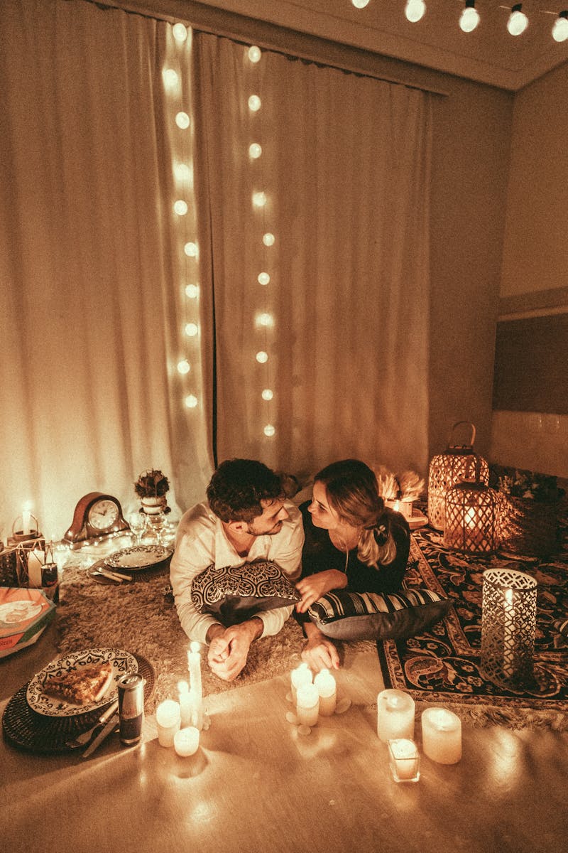 Un cadre romantique et confortable avec des bougies et des lumières créant une ambiance chaleureuse pour une soirée à l'intérieur.