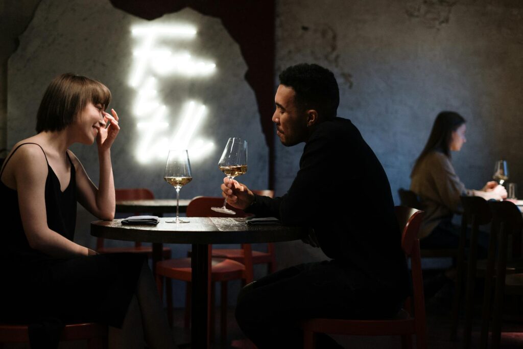 Couple profitant d'une soirée romantique avec du vin blanc dans un bar élégant.