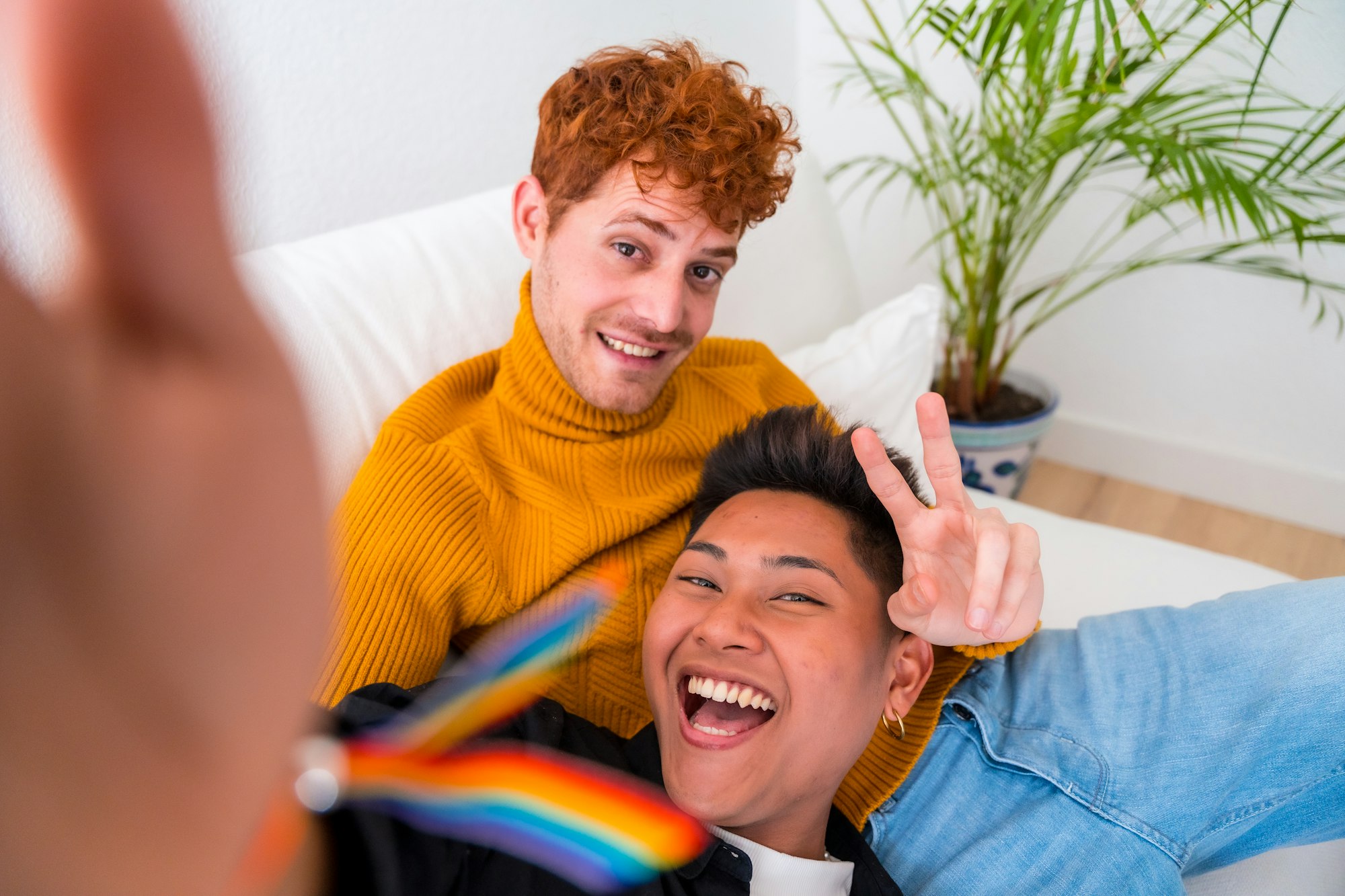 Vackert gaypar som är romantiska inomhus hemma på soffan, gaypar som tar selfie och gör