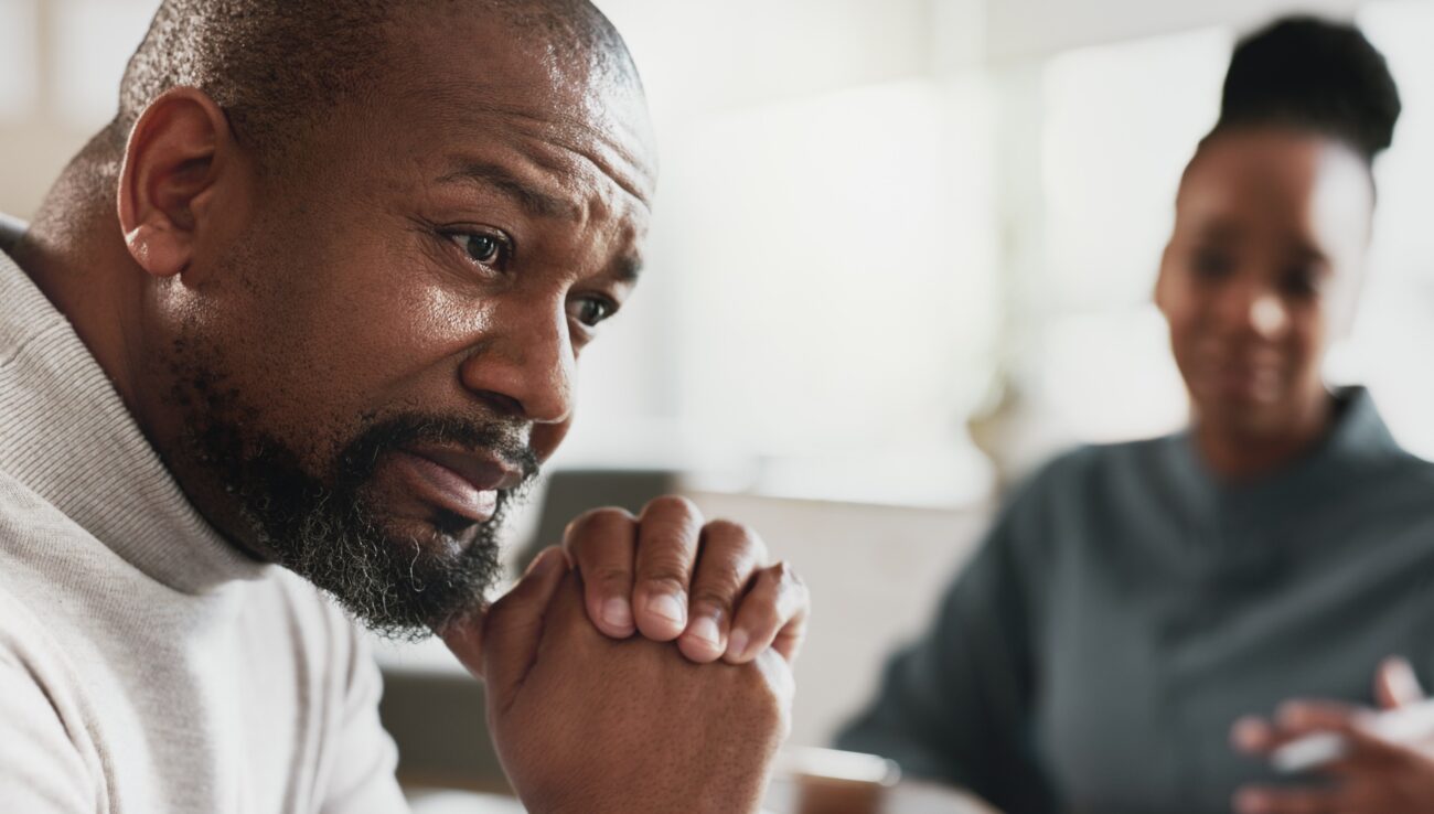 Svart man, stress eller terapisession med terapeut för ångest, hjälp eller mental hälsa vid tidsbeställning