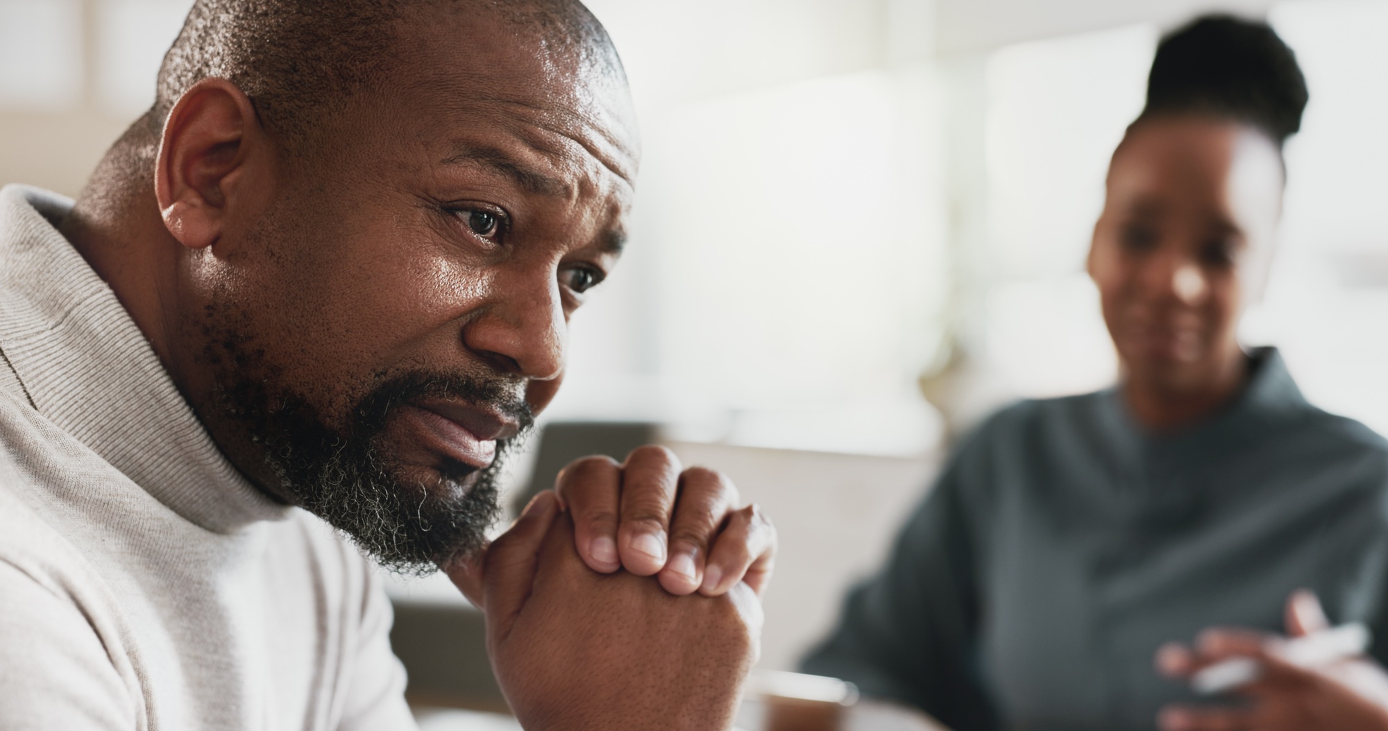 Svart man, stress eller terapisession med terapeut för ångest, hjälp eller mental hälsa vid tidsbeställning