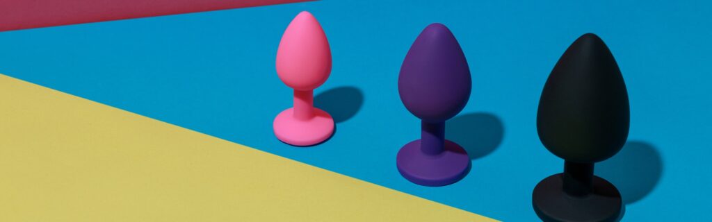 Different colored buttplug sex toys with contrast shadows. Anal toys for adult. Sex shop concept