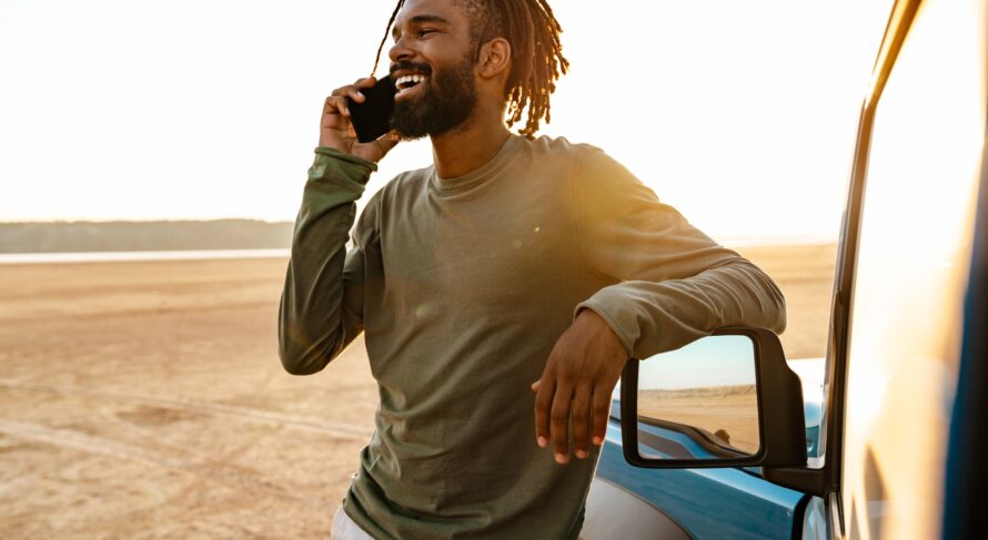 Image of african american man talking on mobile phone while travelling