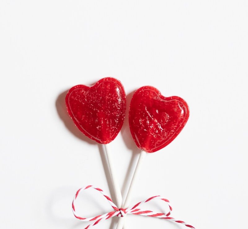 deux sucettes en forme de cœur attachées sur une surface blanche