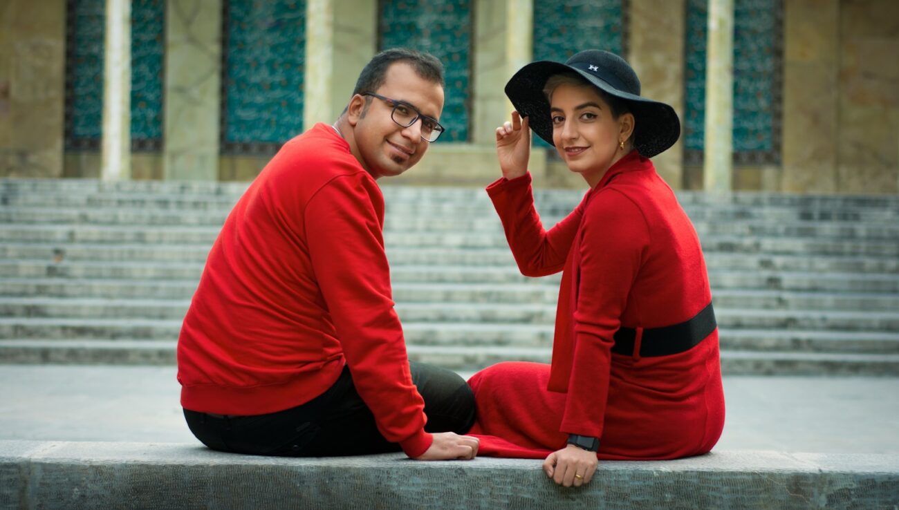 homme en chemise rouge et noire à manches longues et chapeau noir