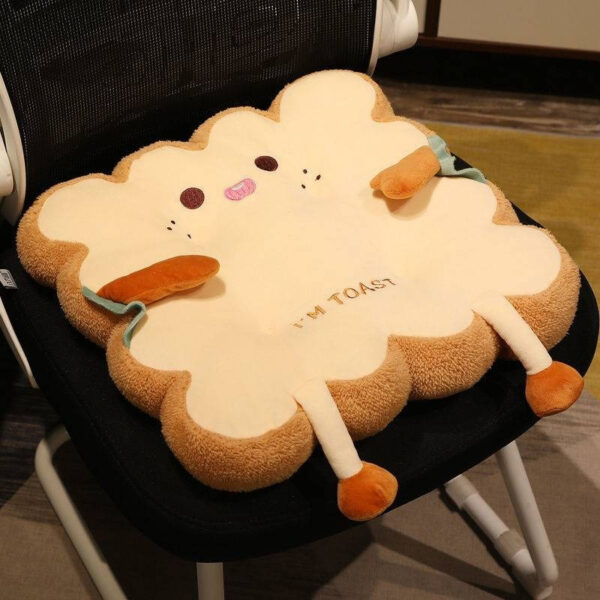 Coussin à toasts en peluche fantaisiste avec un visage joyeux, parfait pour un décor douillet et confortable.