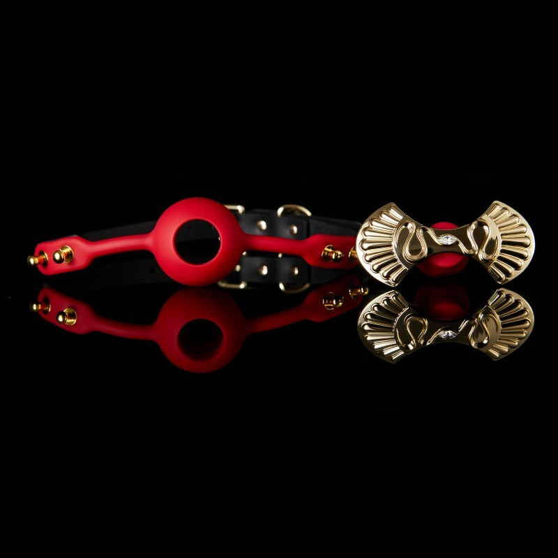 Vibrant red harness with gold accents and ornate brooch, perfect for luxury accessory lovers.