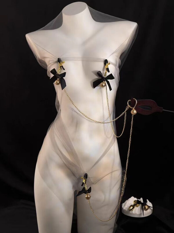 Sheer fashion outfit with gold accents and playful ribbons on a mannequin, showcasing bold elegance.