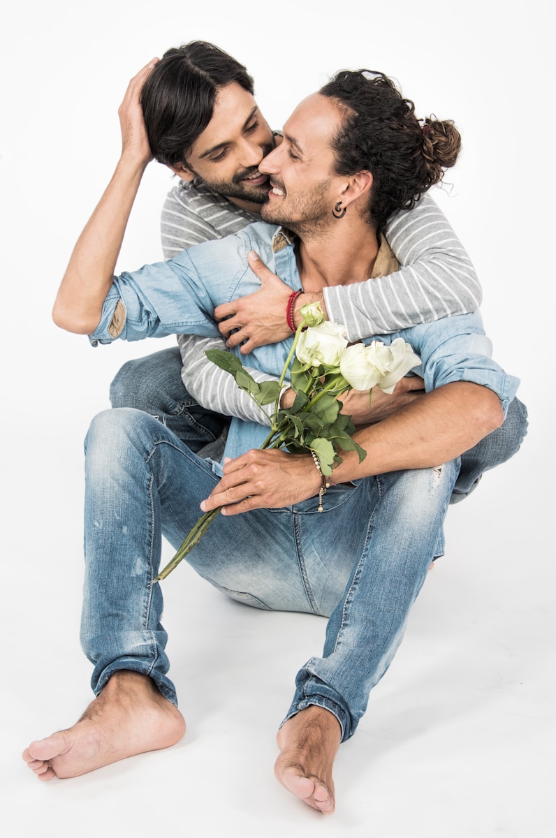 en man sitter på marken och håller i en blombukett