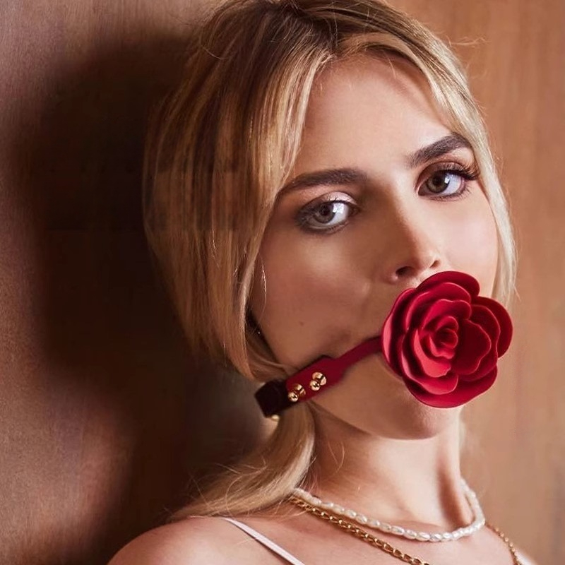 Young woman with rose gag and pearl necklace in elegant wood-paneled setting.