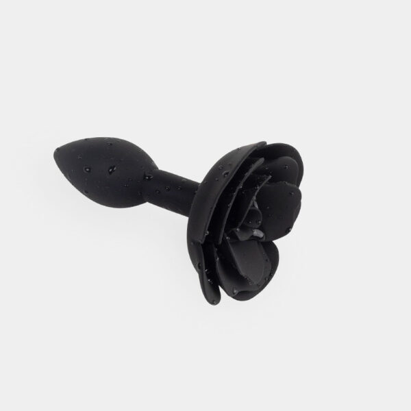 Elegant black rose-shaped accessory with water droplets, perfect for sensual experiences.